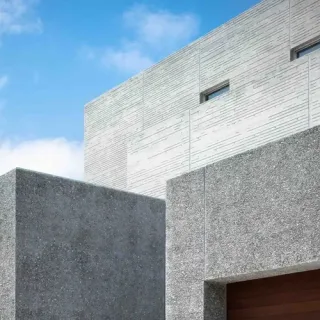 Building facade finished in textured decorative mortar under a blue sky